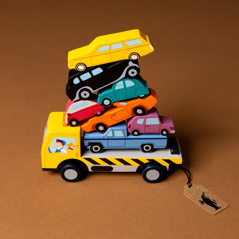 wooden-stacking-cars-play-set Stack of colorful toy cars on a yellow truck with a brown background