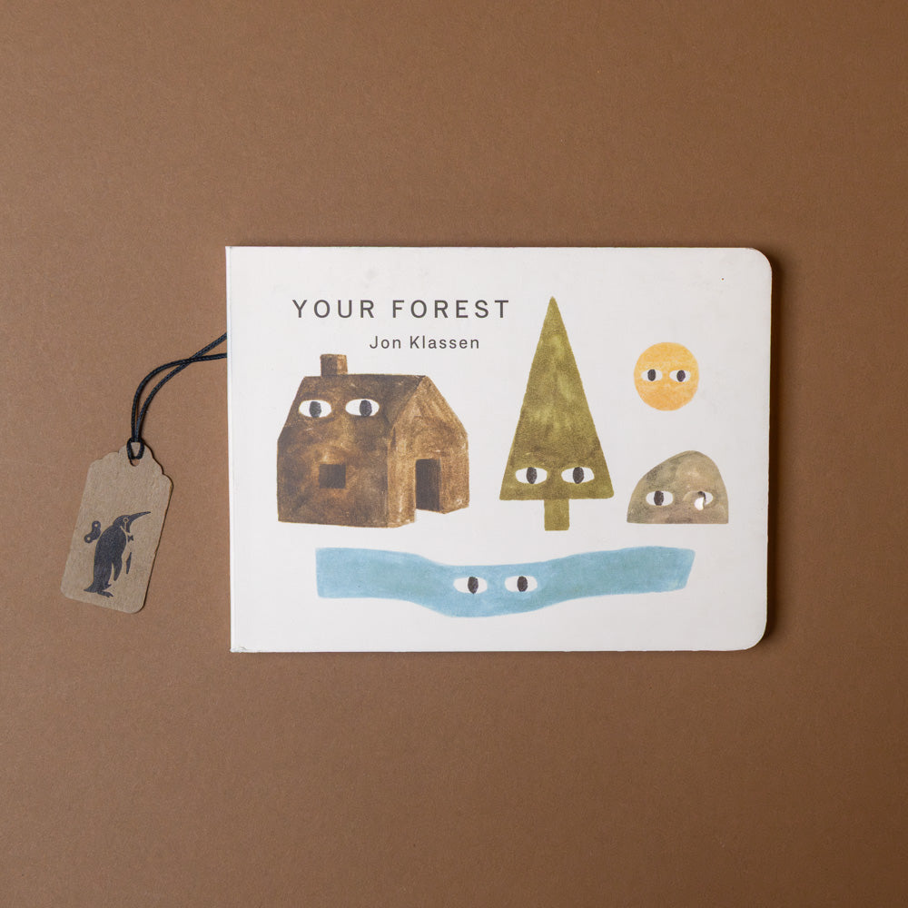 Children's book titled 'Your Forest' by Jon Klassen with illustrations of a house, tree, and rocks on a brown background.
