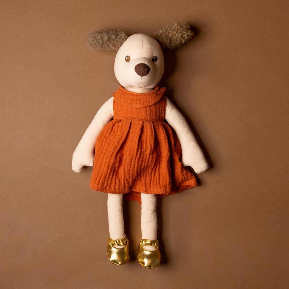 amy-the-puppy Stuffed toy in an orange dress and gold shoes on a brown background