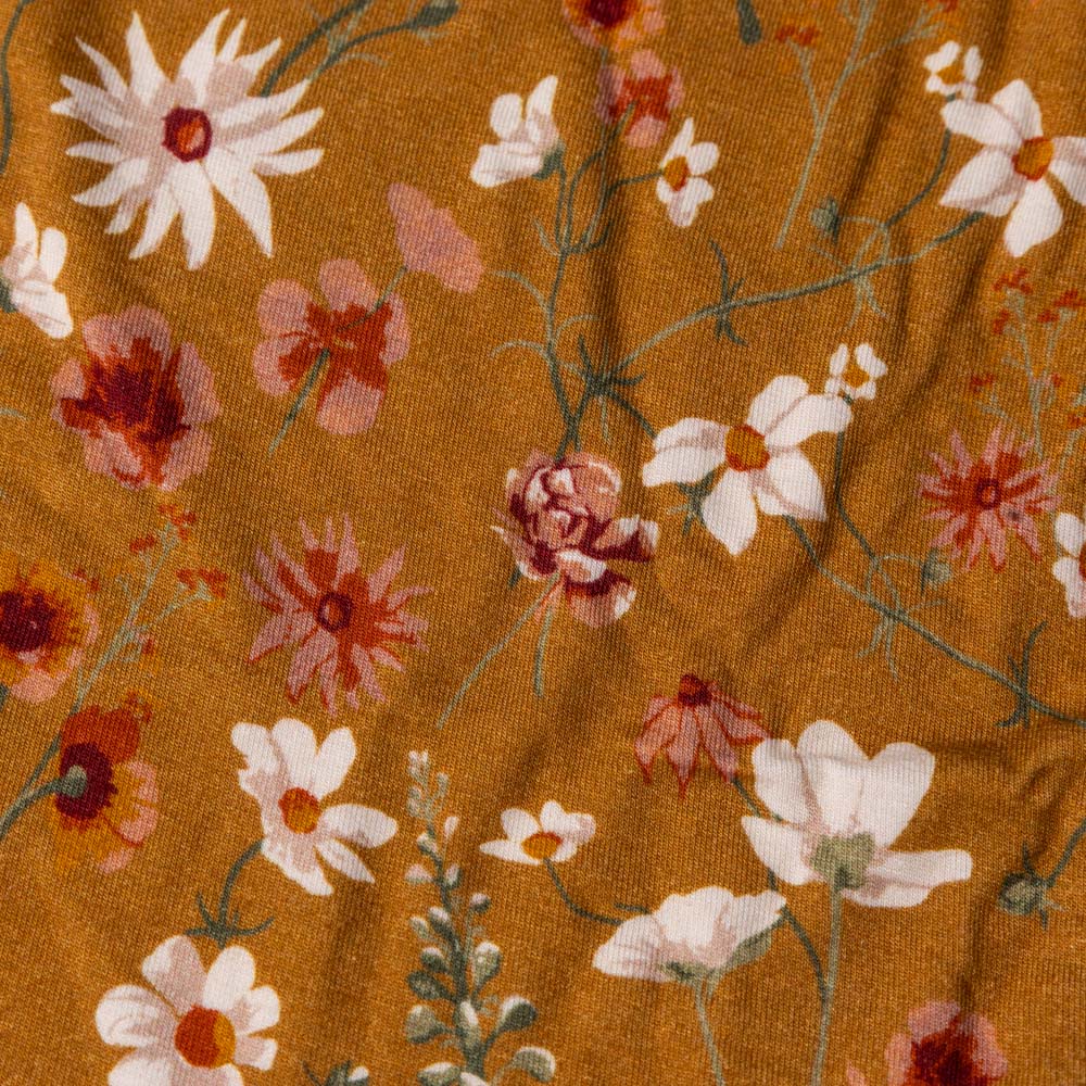 bamboo-long-sleeve-stretch-onesie-wildflower Floral pattern with red, white, and pink flowers on a brown background