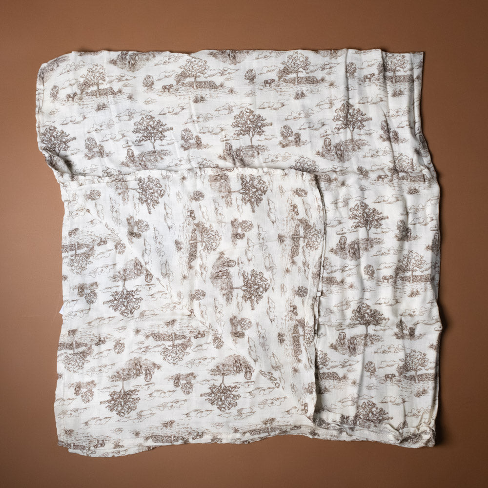 bamboo-swaddle-meadow-toile with tree pattern on a brown background