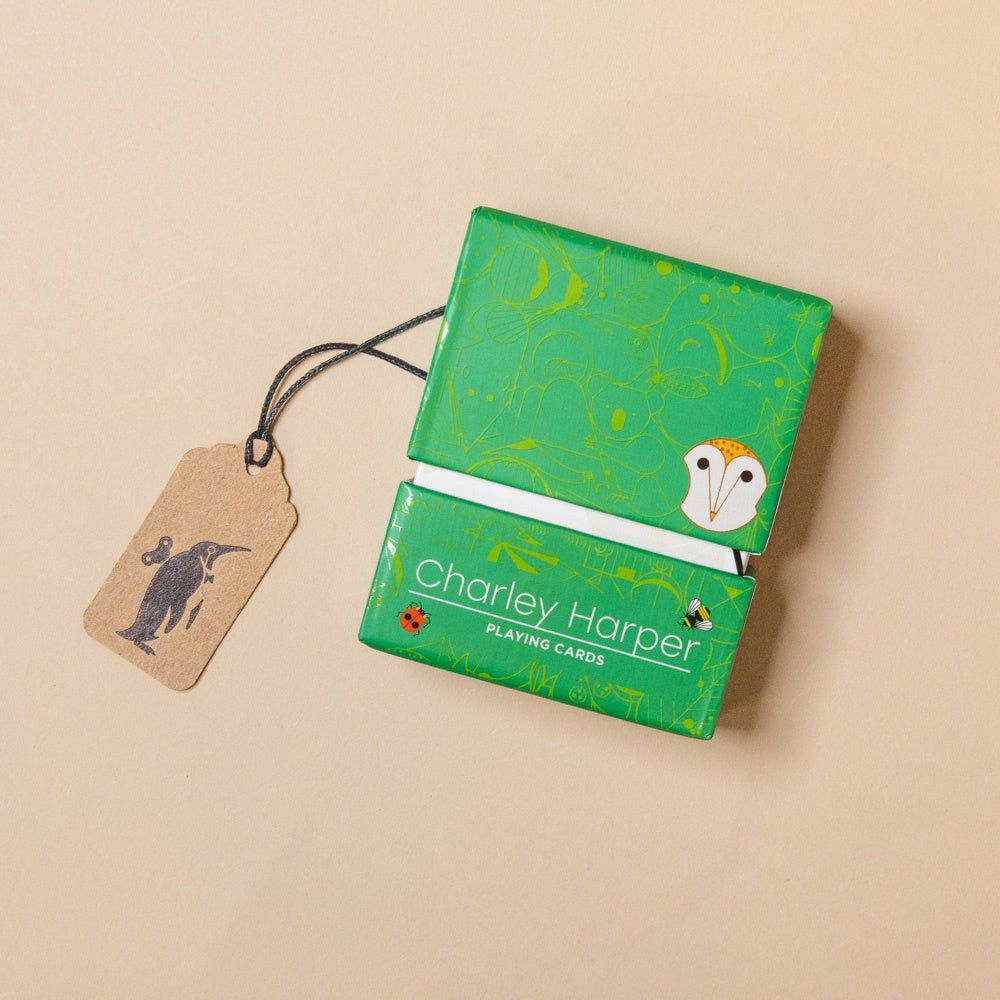 Green playing card box with Charley Harper branding on a beige background
