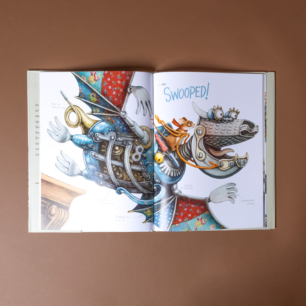 emmie-builds-something-new Open book with colorful illustrations of a dragon and a mechanical bird on a brown background