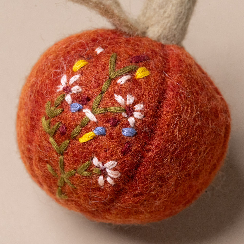 felt-embroidered-pumpkin-ornament-rust Orange felt pumpkin embroidered floral design on a neutral background