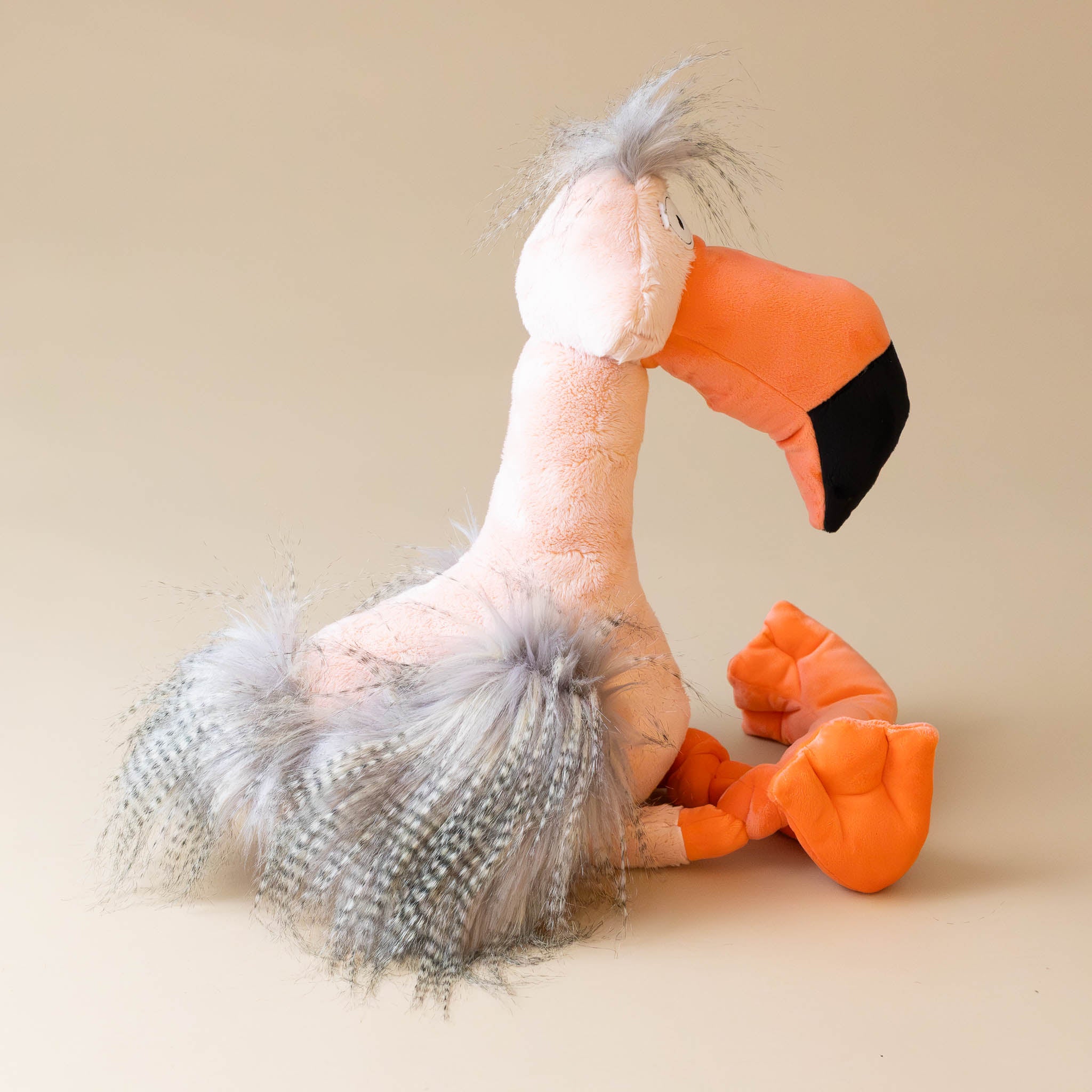 fool-flamingo-with-salmon-body-orange-beak-and-legs-and-grey-tufts-side