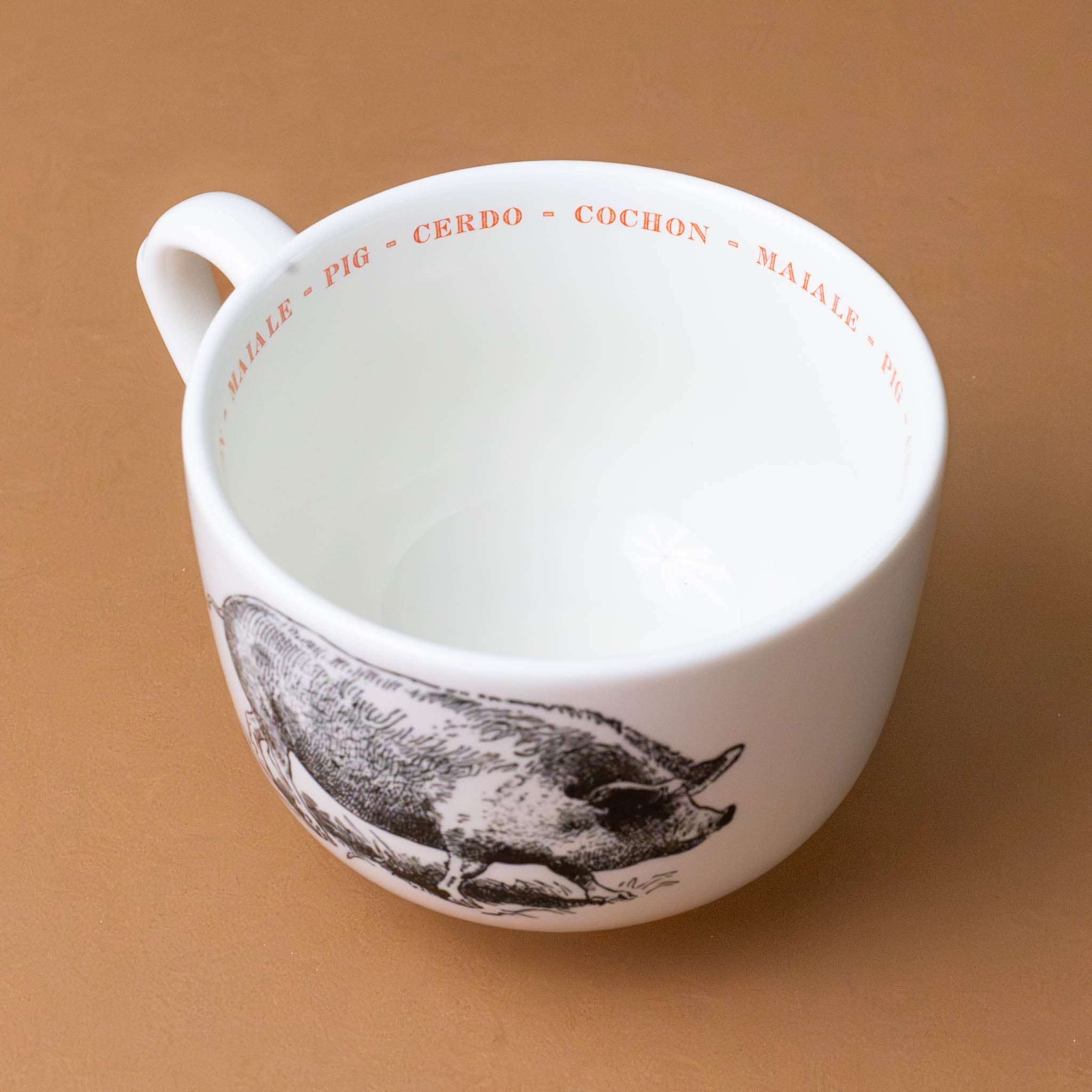 white-grande-stoneware-cup-black-illustration-pig-with-the-word-pig-in-pink-in-several-different-languages-on-interior-of-cup