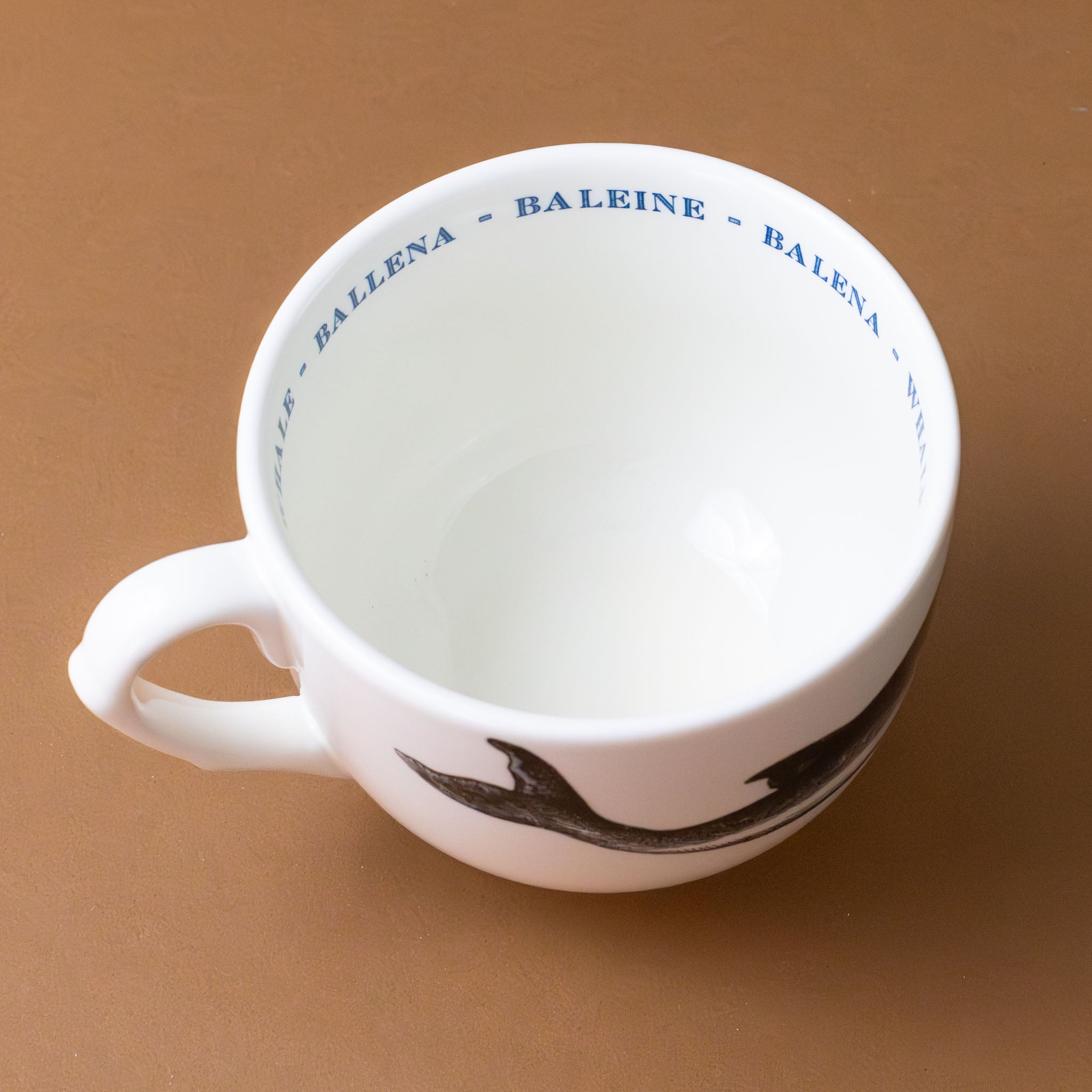 white-grande-stoneware-cup-black-illustration-whale-with-the-word-whale-in-blue-in-several-languages-on-interior-of-cup