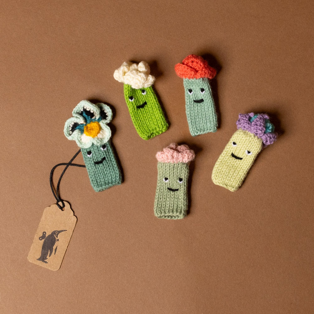 hand-knit-finger-puppet-set-flowers toys with colorful flowers on a brown background