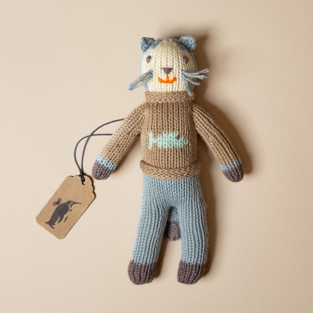 hand-knit-rattle-sardine-kitten with a sweater and pants on a beige background