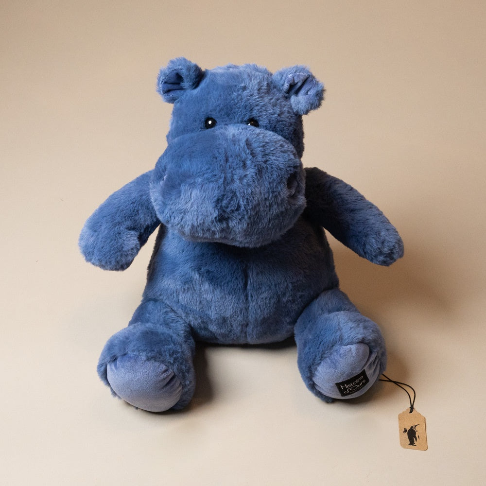 hip-hippo-ocean-blue-medium plush hippo toy with a tag on a beige background