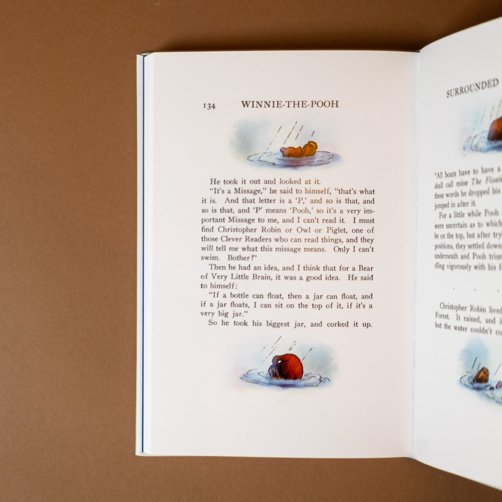leather-bound-winnie-the-pooh-classic-edition Open book with text and illustrations on a brown background