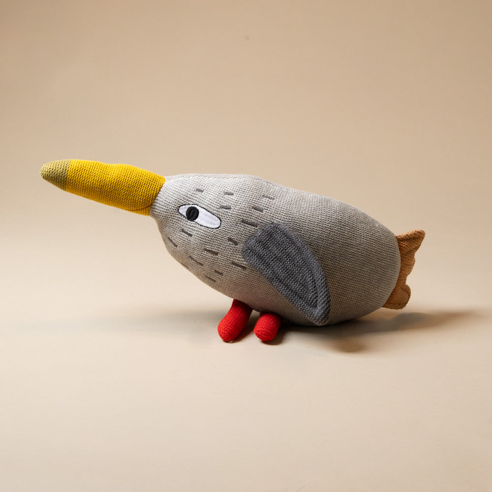 lily-hen Plush toy bird with a yellow beak, gray body, and red legs on a beige background