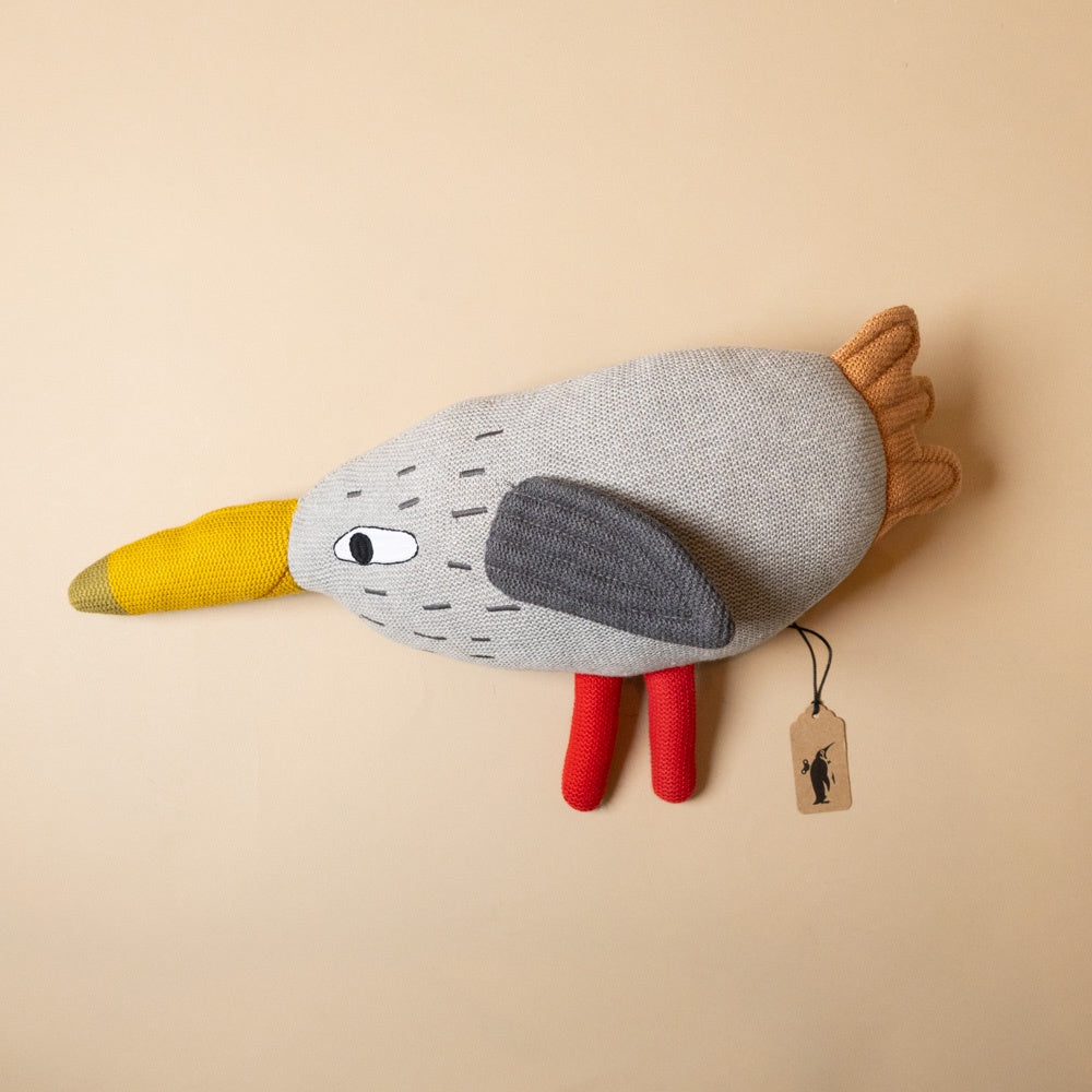 lily-hen Plush toy bird with a yellow beak, gray body, and red legs on a beige background