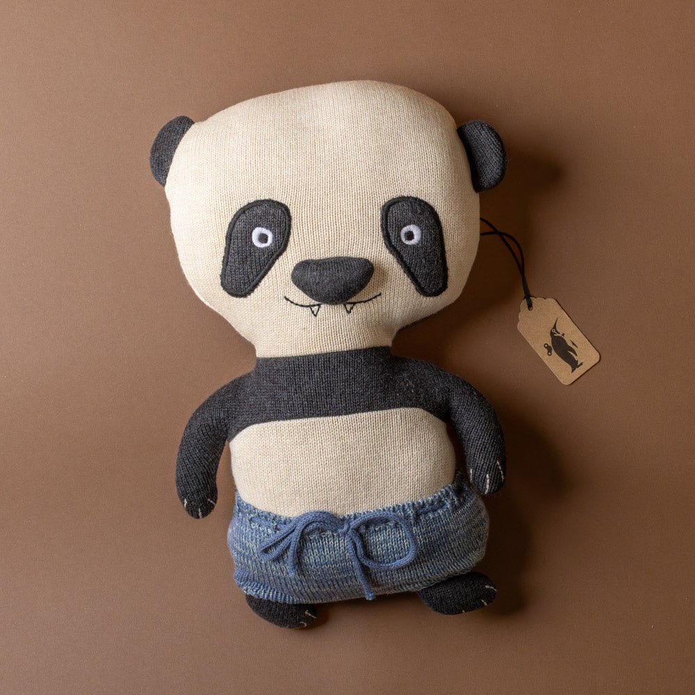 ling-ling-panda-bear Stuffed panda toy with denim pants with a tag on a brown background
