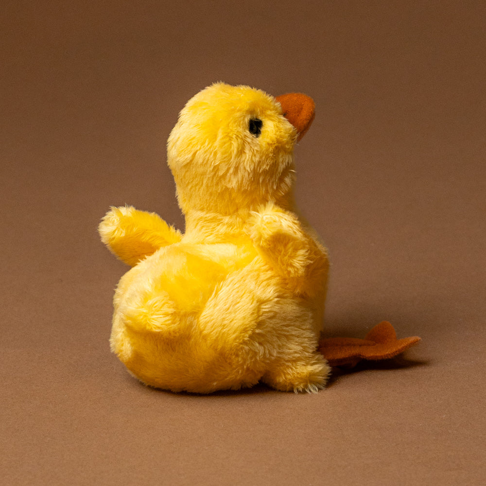 little-duck-chick-finger-puppet tail feathers on a brown background