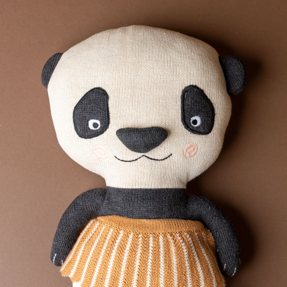 lun-lun-panda-bear Stuffed panda toy with a brown background