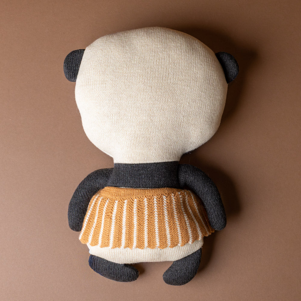 lun-lun-panda-bear Stuffed toy panda -back with a striped sweater dress on a brown background