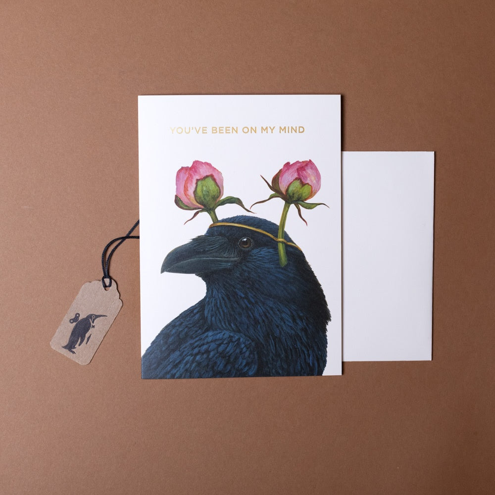 Greeting card with a crow and flowers on a brown background