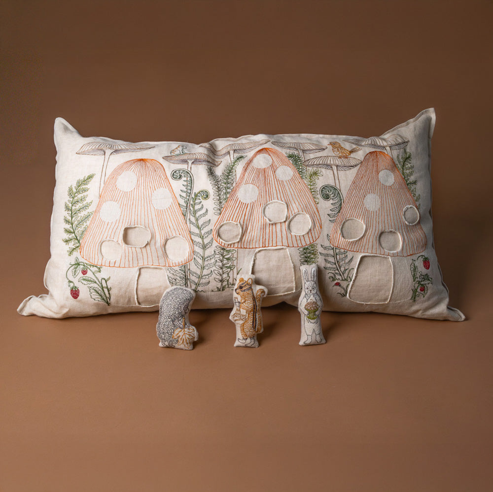 mushroom-forest-pocket-pillow Decorative pillow with mushroom design on a brown background