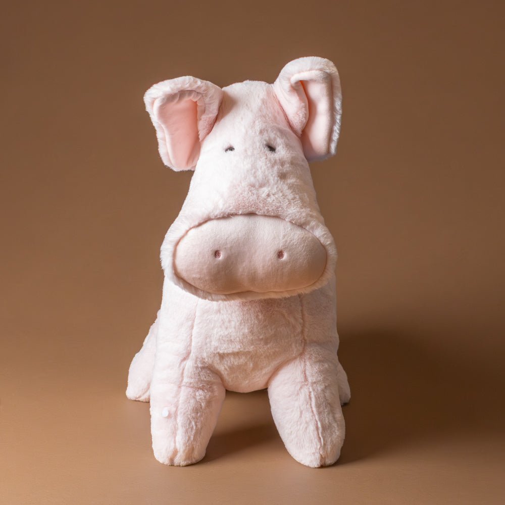 muzzle-peter-pig-jumbo Plush pig toy on a brown background