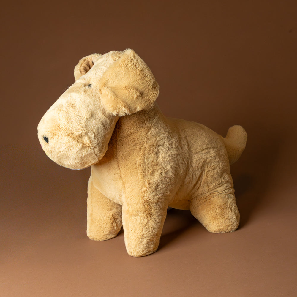 muzzle-tim-tan-pup-jumbo Beige stuffed animal toy on a brown background