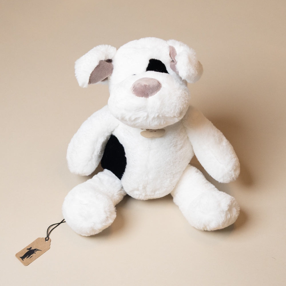 White plush noopy-dog toy with a black spot on a beige background