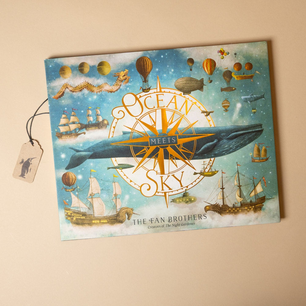 Book cover with 'Ocean Meets Sky' design featuring ships, whales, and hot air balloons on a beige background.