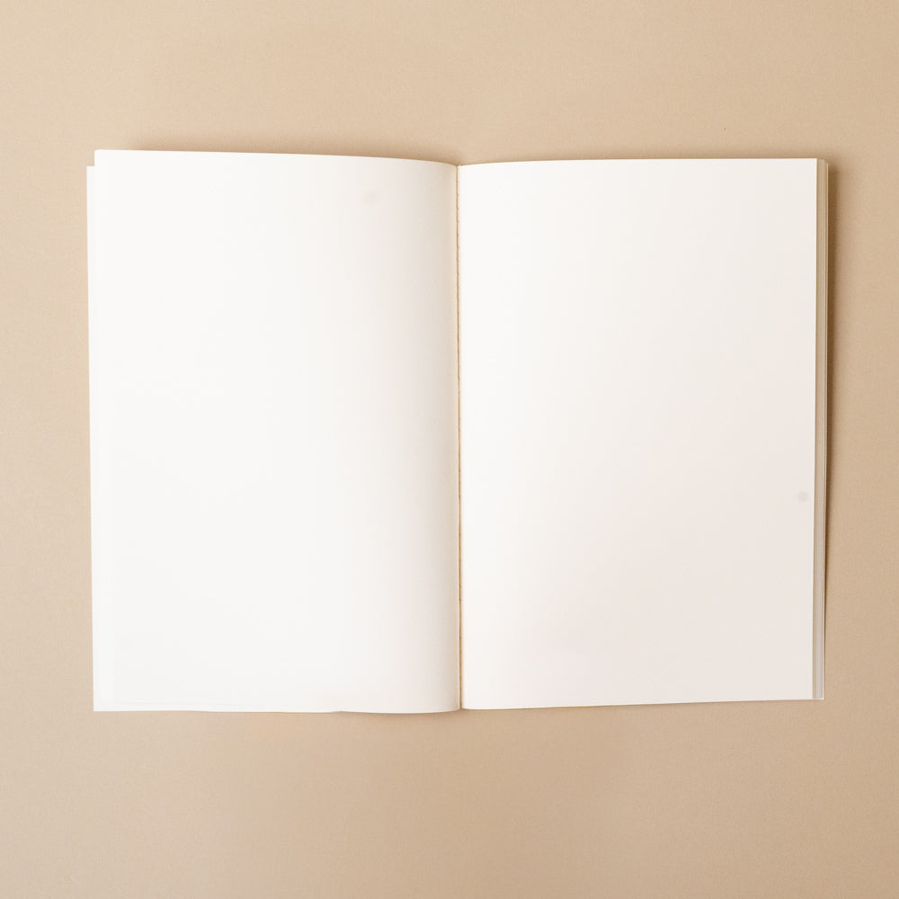 only-good-things-notebook Open notebook with blank pages on a beige background