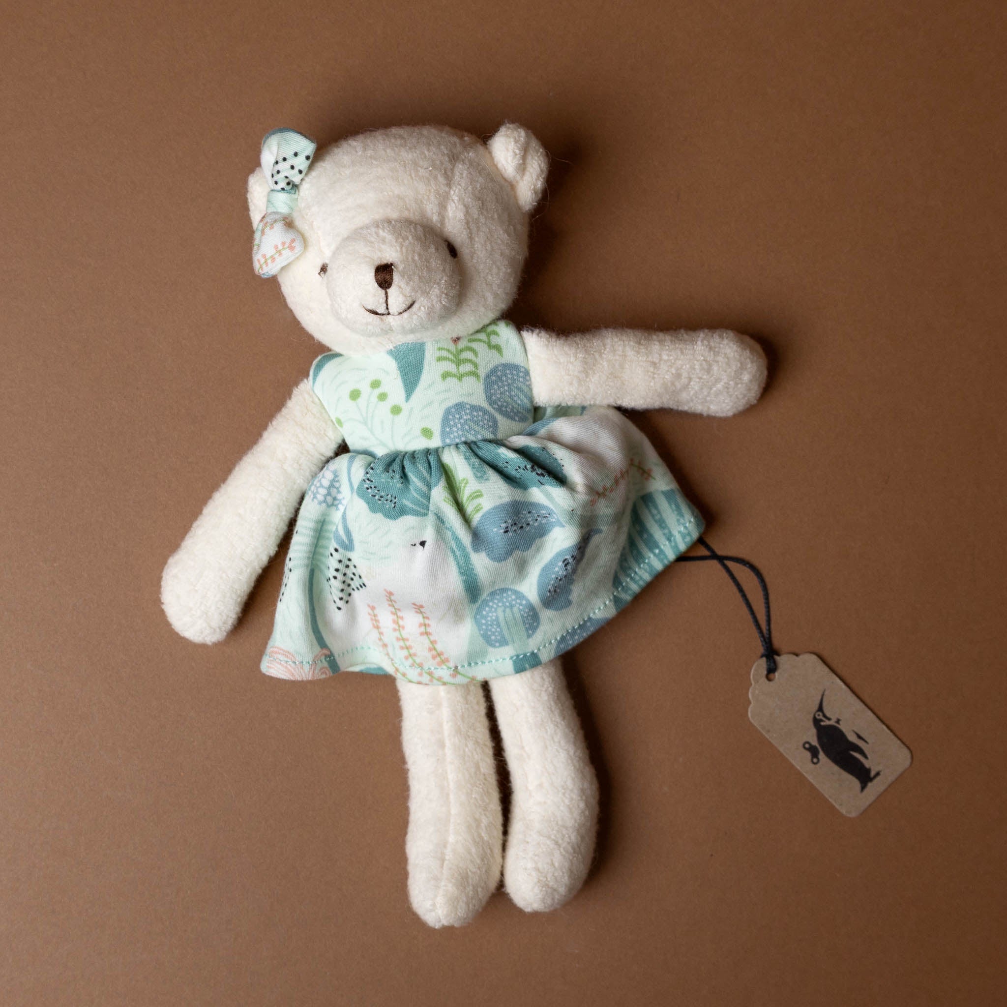 organic-cotton-polar-bear-friend-sea-blue-dress with a tag on a brown background