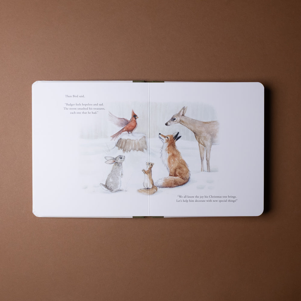 our-little-adventure-at-christmas-board-book Open book with illustrations of various animals in a snowy scene on a brown background