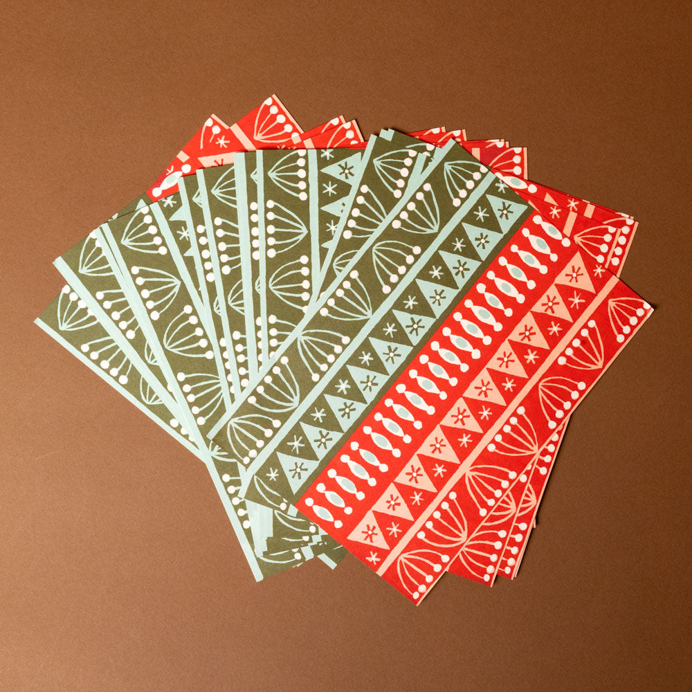 Set of red and green patterned paper sheets on a brown background