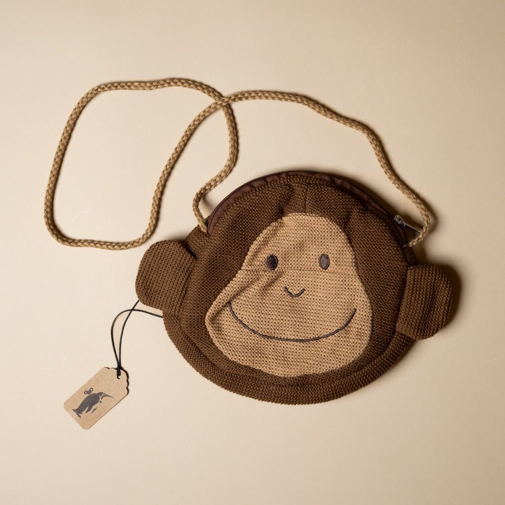 paulo-the-monkey-pocket-purse Knitted monkey bag with a smiley face on a beige background