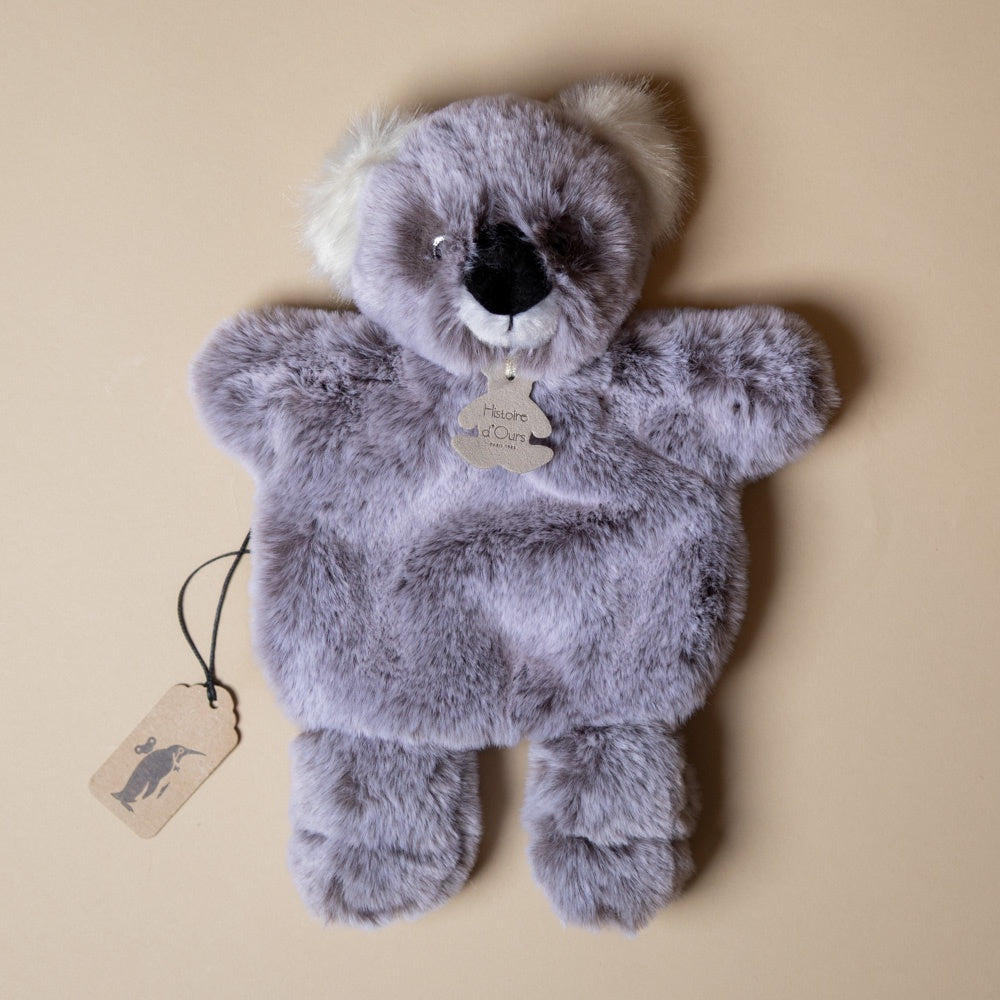 Plush toy petite-koala-bear-lovie with a tag on a beige background
