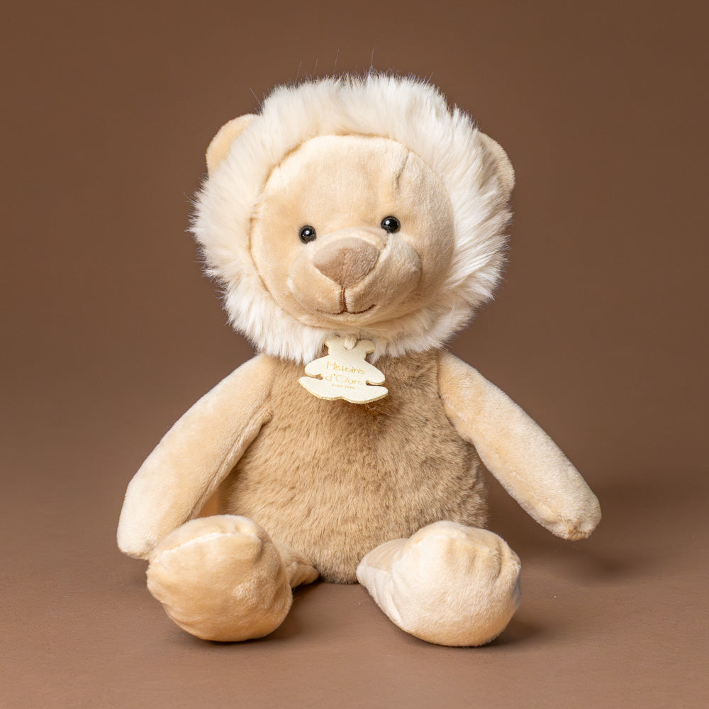 petite-lion-cub Plush lion toy with a brown background