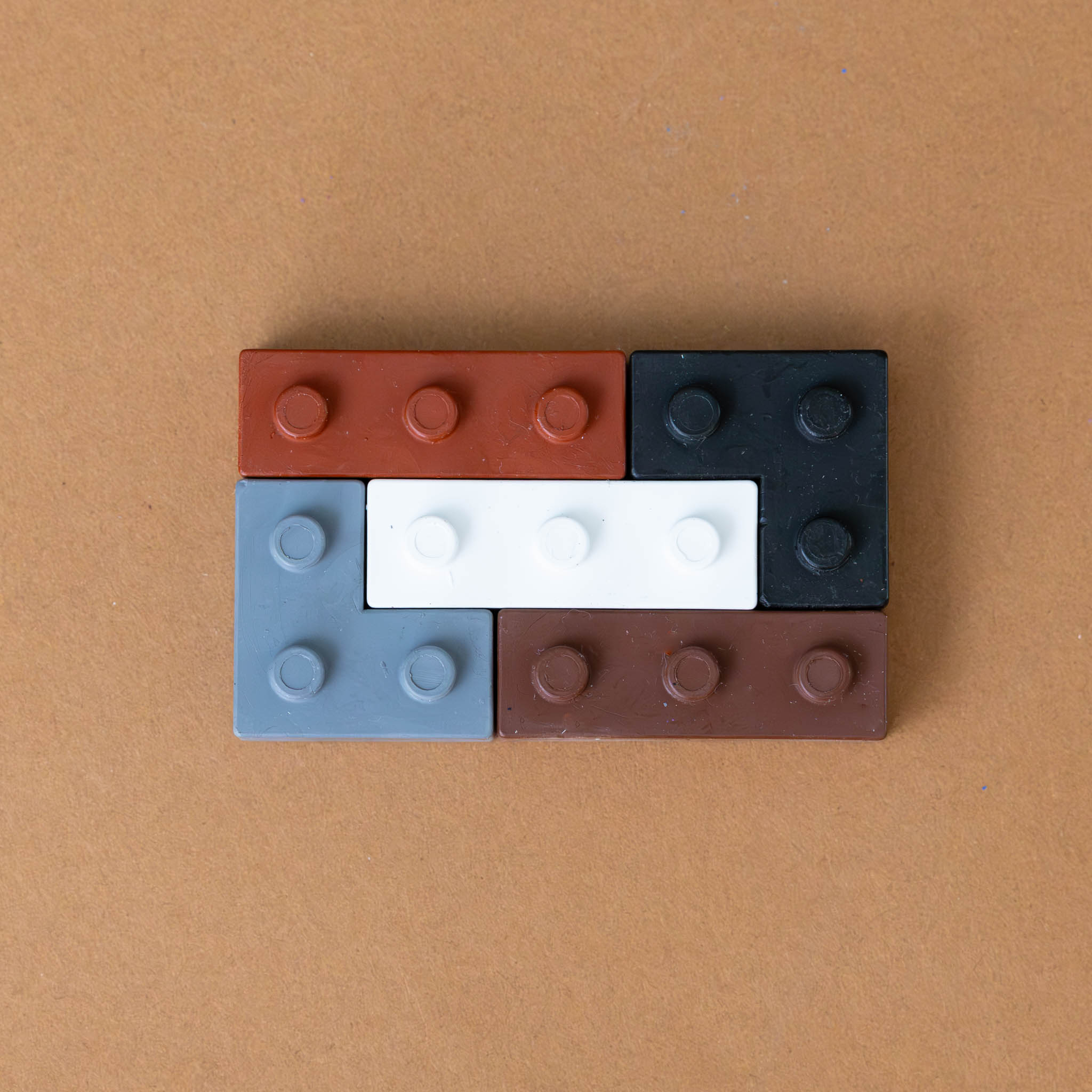pocket-5-crayons-warm-grey-shaped-like-building-blocks-in-grey-black-and-browns-forming-rectangle