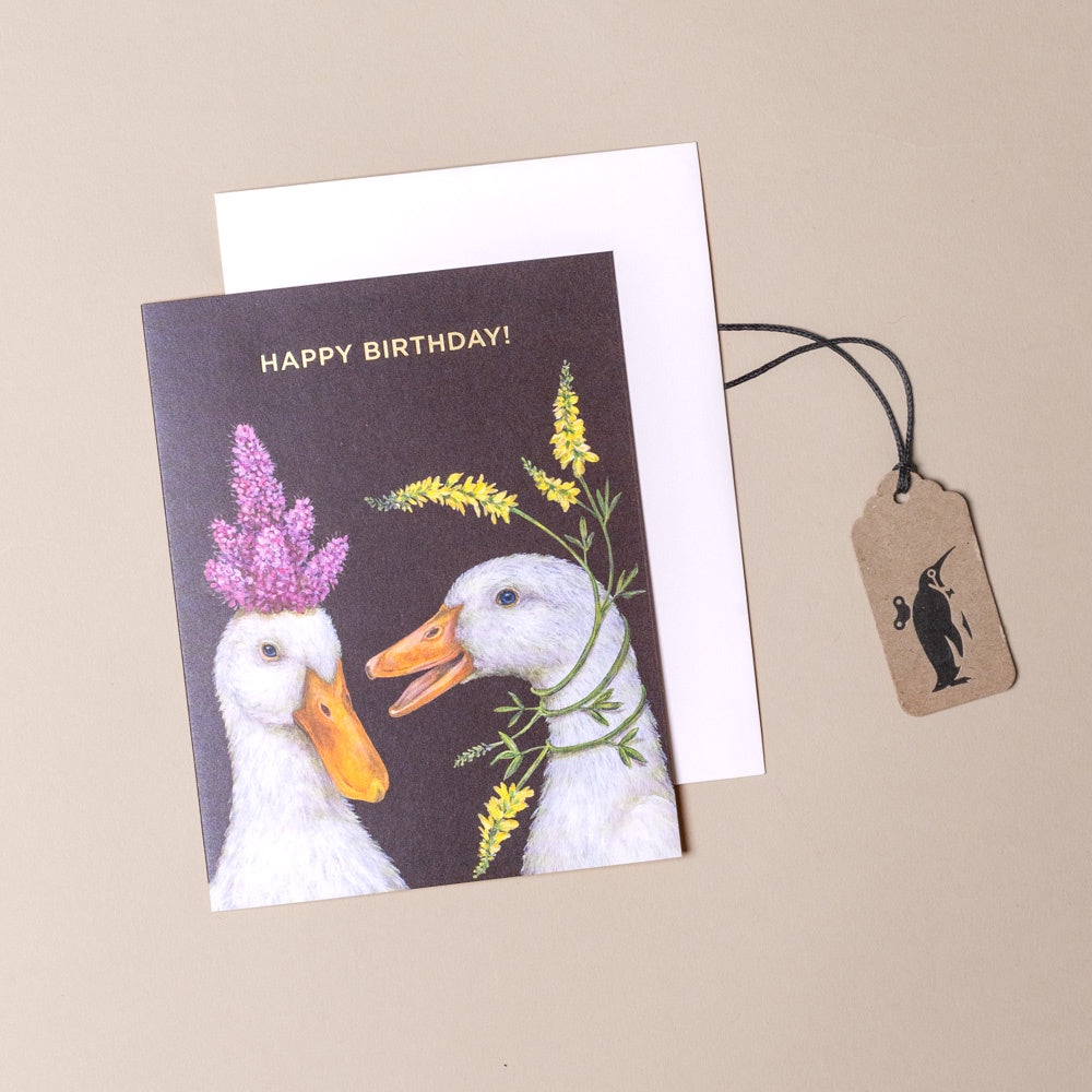 Birthday card with two ducks and flowers on a beige background