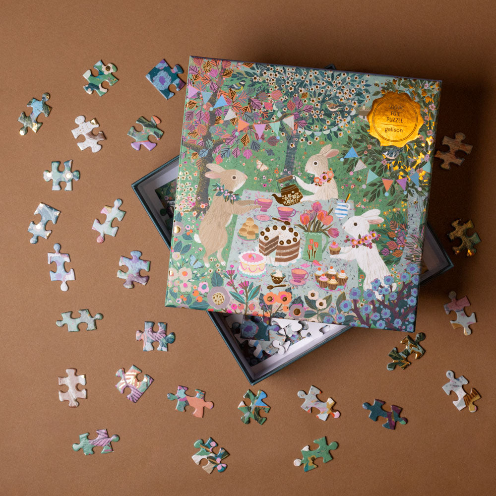 spring-tea-party-500-piece-puzzle Jigsaw puzzle with completed pieces and a box on a brown background