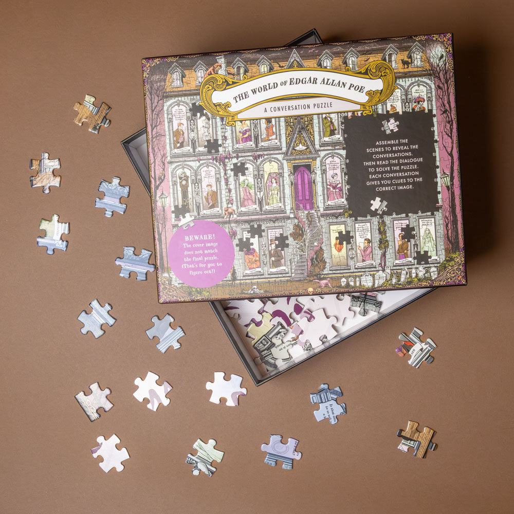 the-world-of-edgar-allen-poe-a-500-piece-conversation-puzzle set with pieces scattered on a brown surface, featuring 'The World of Edgar Allan Poe' packaging.