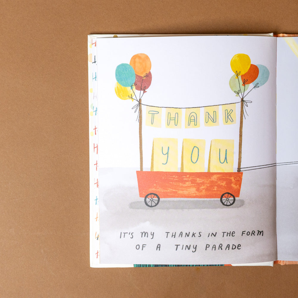 this-isnt-a-book-its-my-thanks-in-disguise  page with colorful balloons and a wagon carrying 'Thank You' signs on a brown background