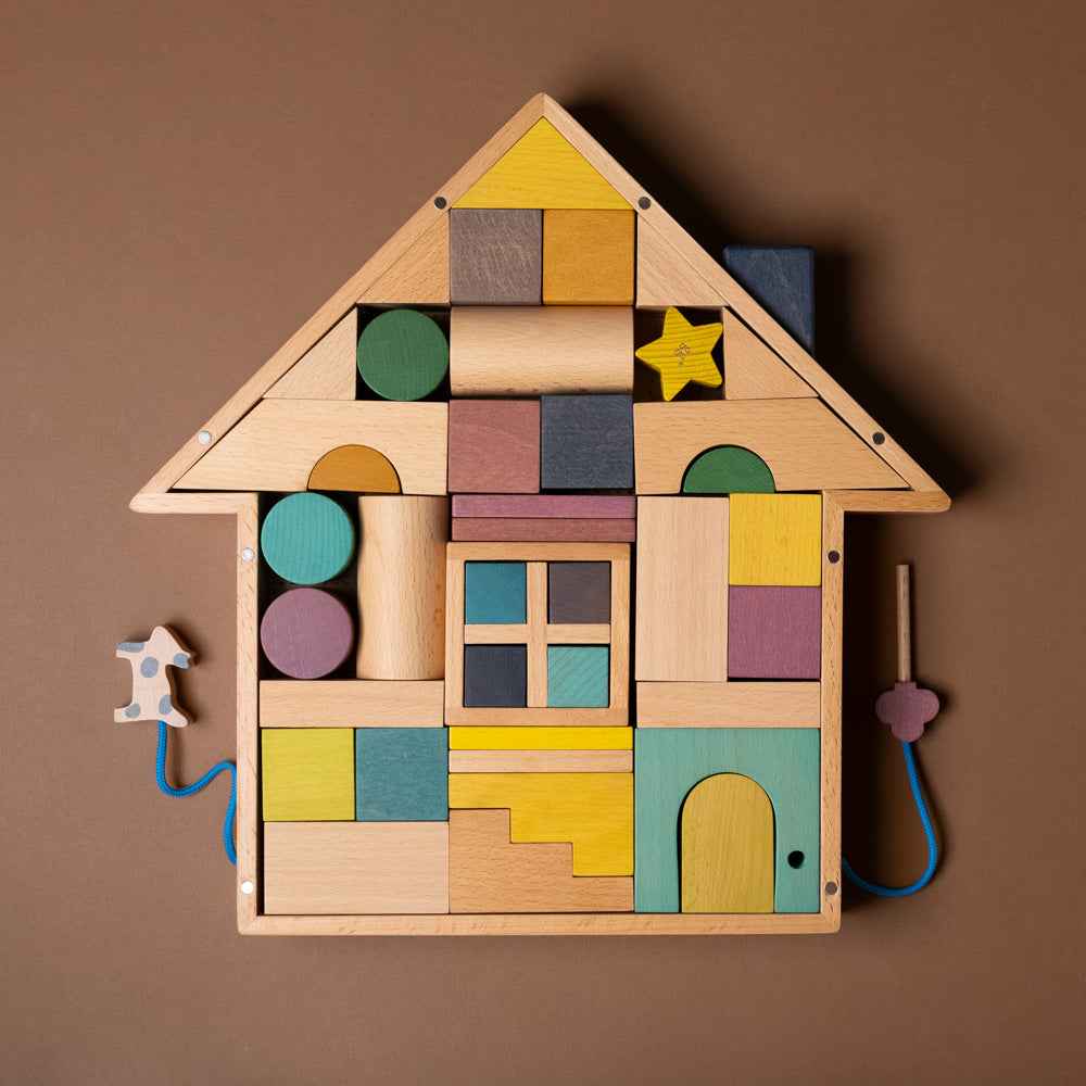 Wooden block house toy with colorful blocks on a brown background