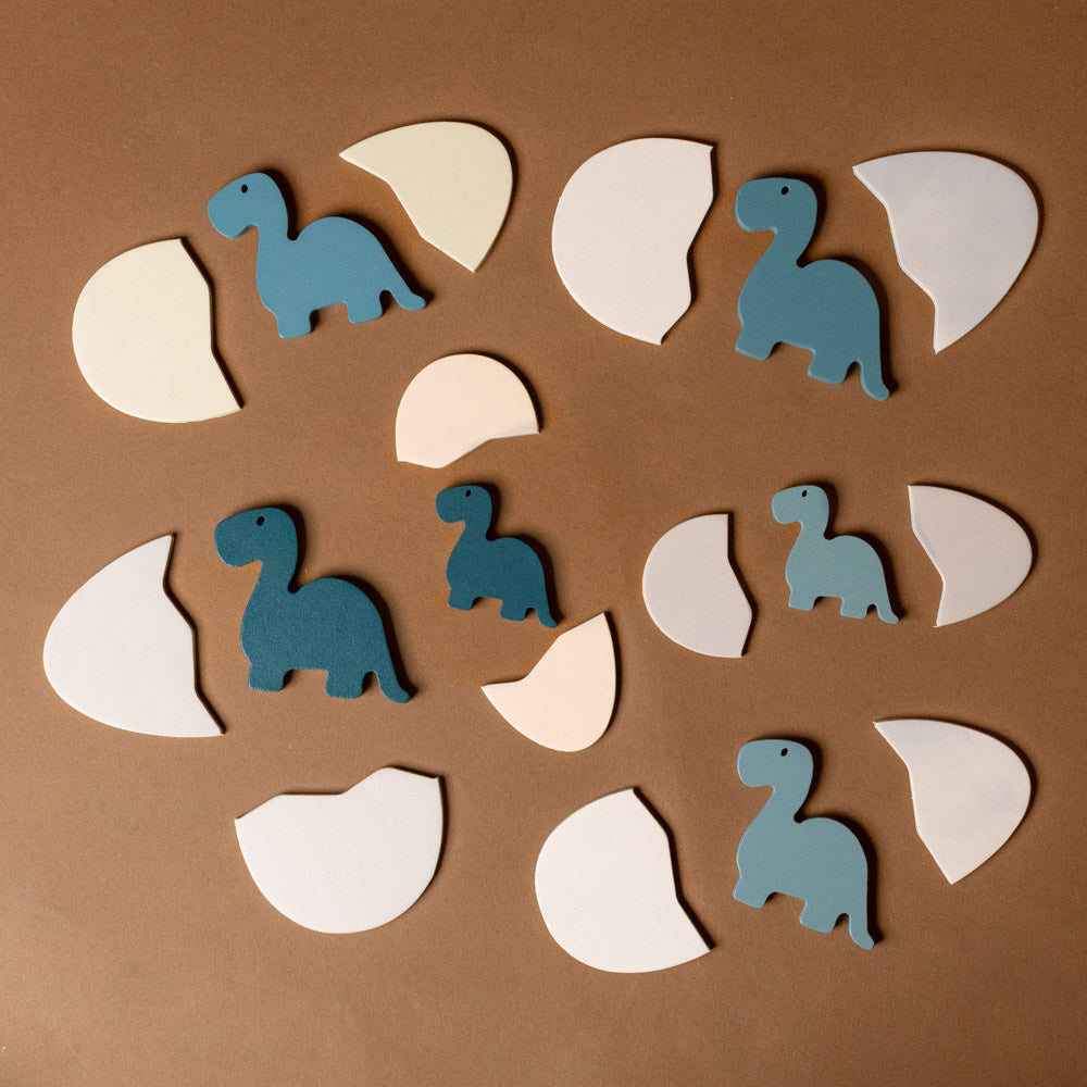 wooden-dino-eggs-puzzle Wooden dinosaur and egg toy pieces on a brown background