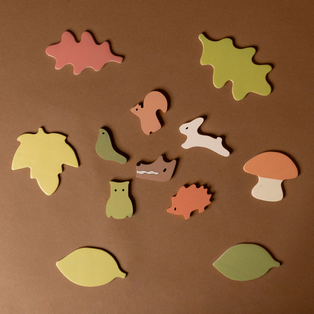 wooden-forest-puzzle Set of colorful animal and leaf-shaped wooden toys on a brown background