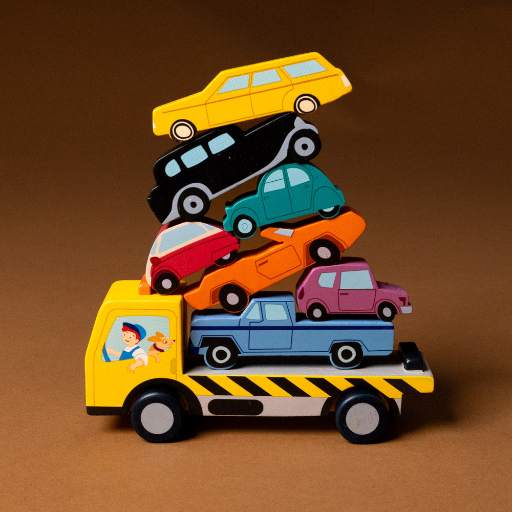 wooden-stacking-cars-play-set Toy truck with a stack of colorful toy cars on a brown background