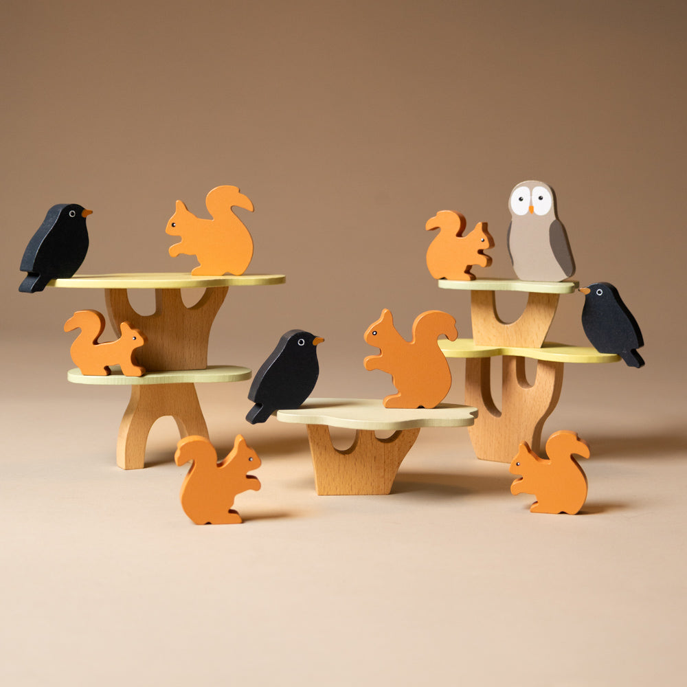 wooden-stacking-squirrels-game Wooden animal figurines on a balance toy with a brown background