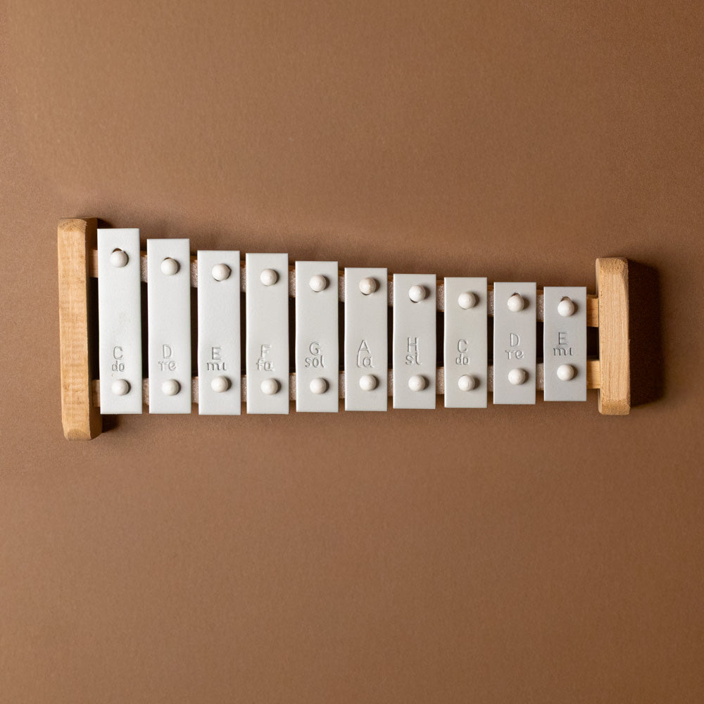 Wooden xylophone-10-note with white keys on a brown background