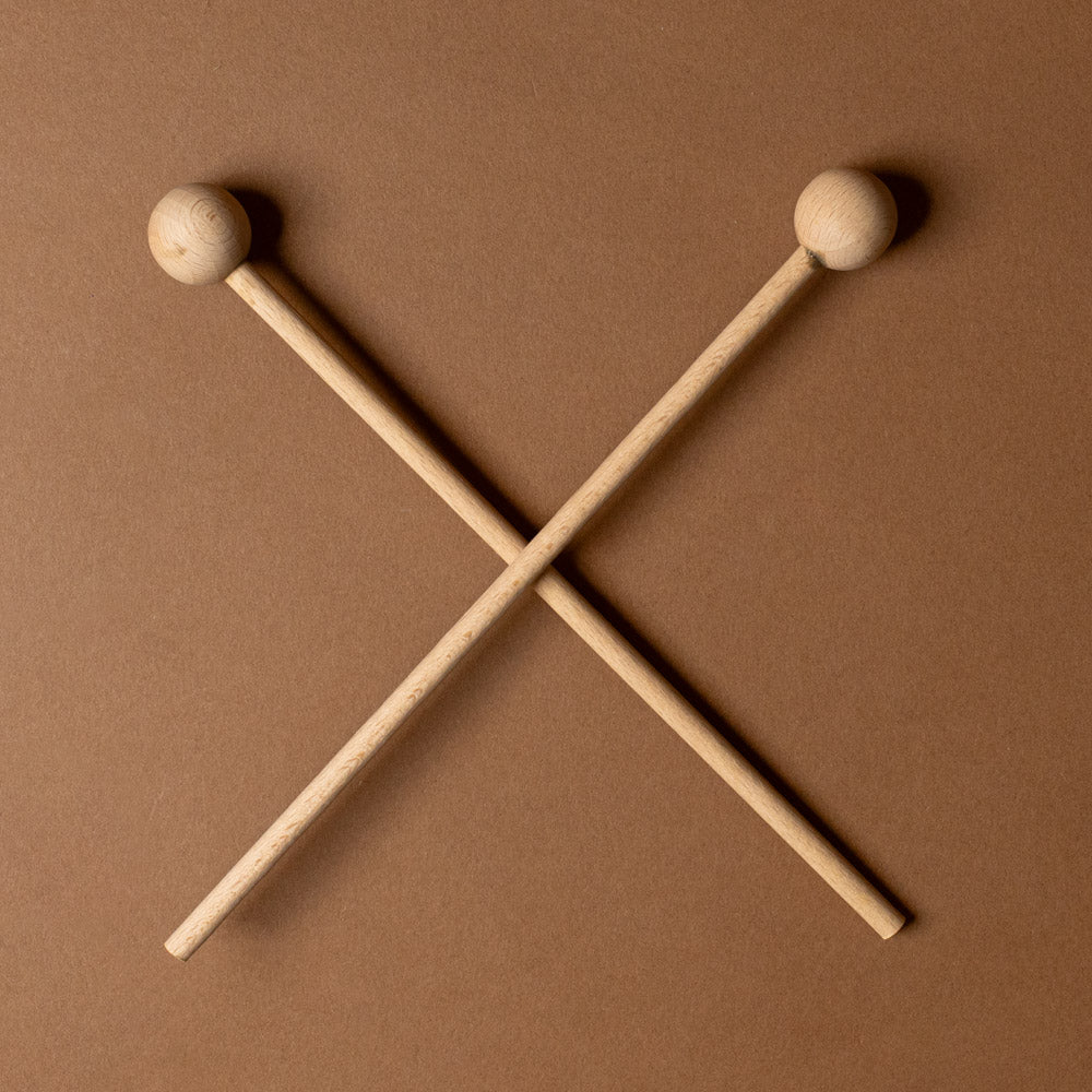 xylophone-10-note Two crossed wooden drumsticks on a brown background
