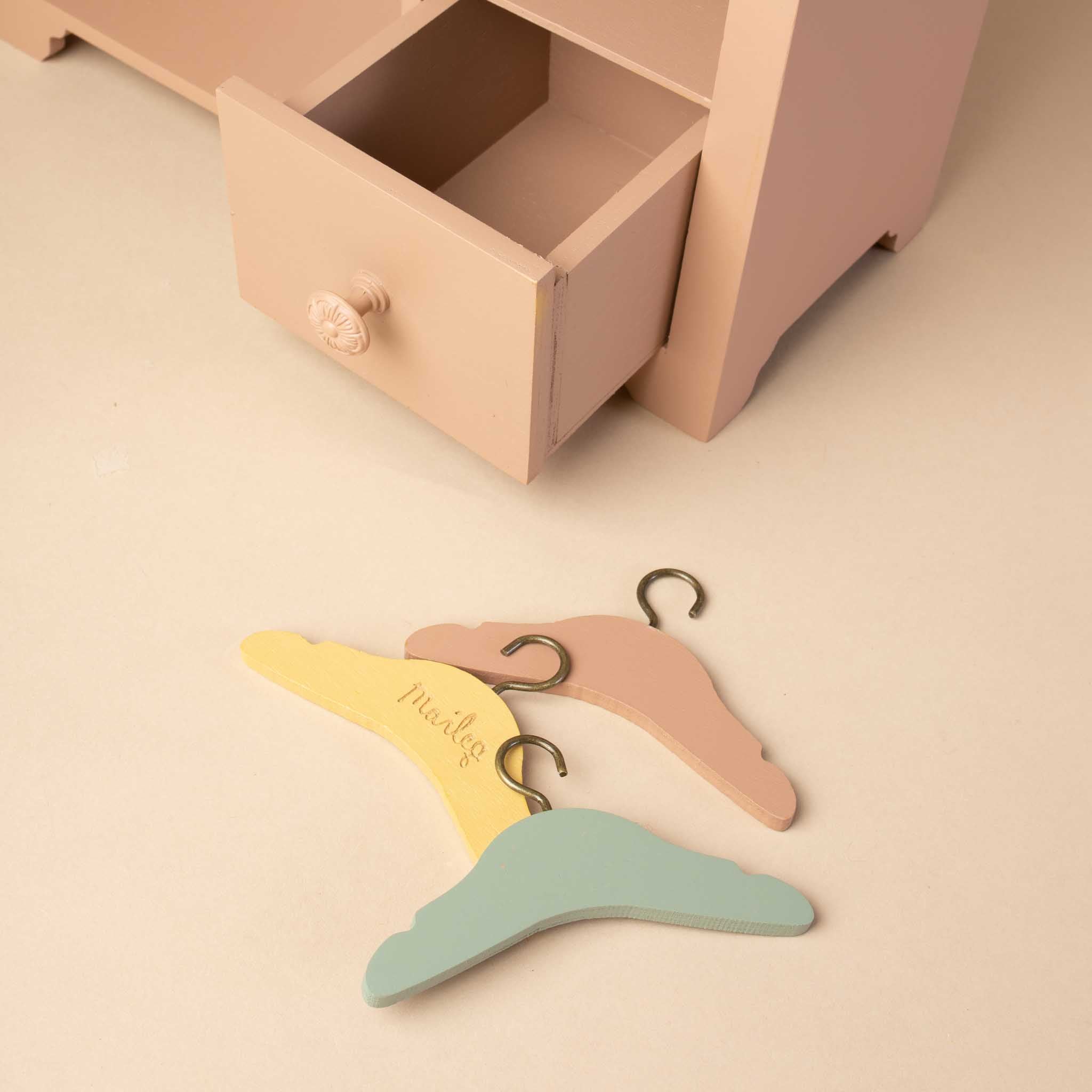 close-up-of-3-hangers-and-open-drawer